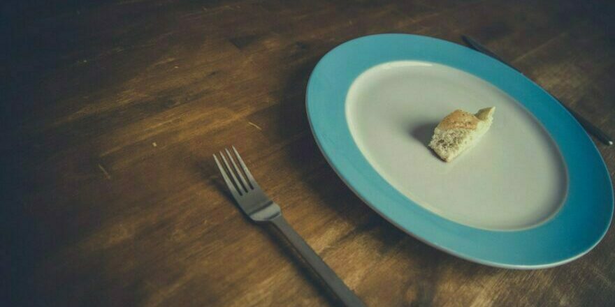 assiette vide avec un petit bout de pain montrant la perte d'appétit