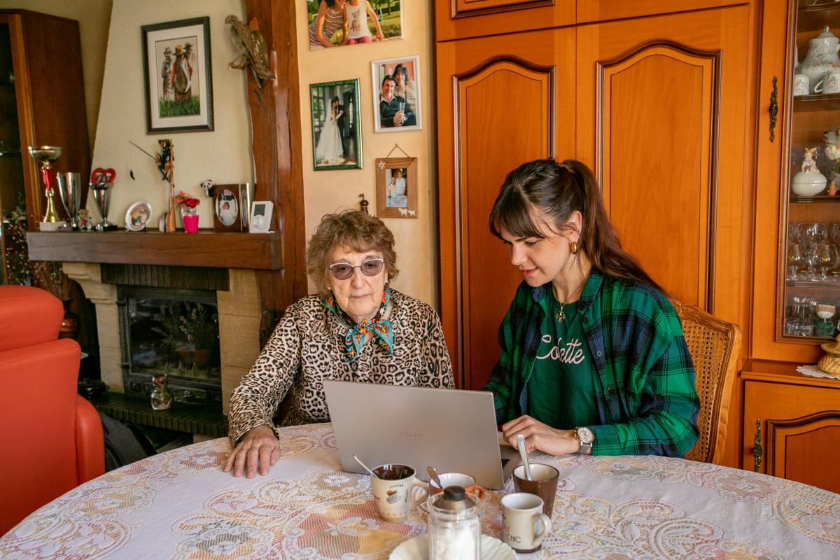 jeune aide senior sur un ordinateur