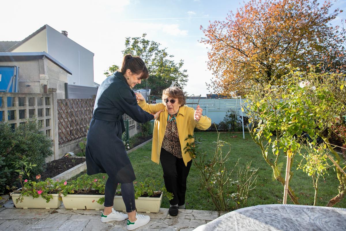 jeune aidant une grand-mere à monter un escalier